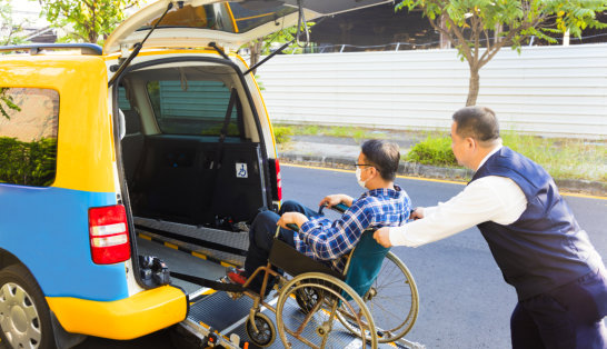 man assisting elderly to get in the car