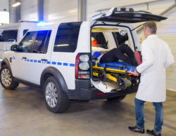 man assisting a man to get in the car